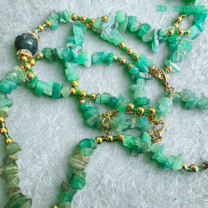 Handmade GREEN AVENTURINE necklace and bracelet set with natural green gemstone chips, gold beads, rhinestone accents, and elegant gold chain details displayed on a soft textured background.
• Close-up view of polished green jade chips mixed with shiny golden spacer beads creating an elegant boho gemstone jewellery design with natural earthy texture and sparkle.