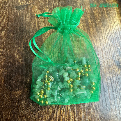 Natural gemstone jewelry with aventurine, African jade, and gold beads on display with gift bag