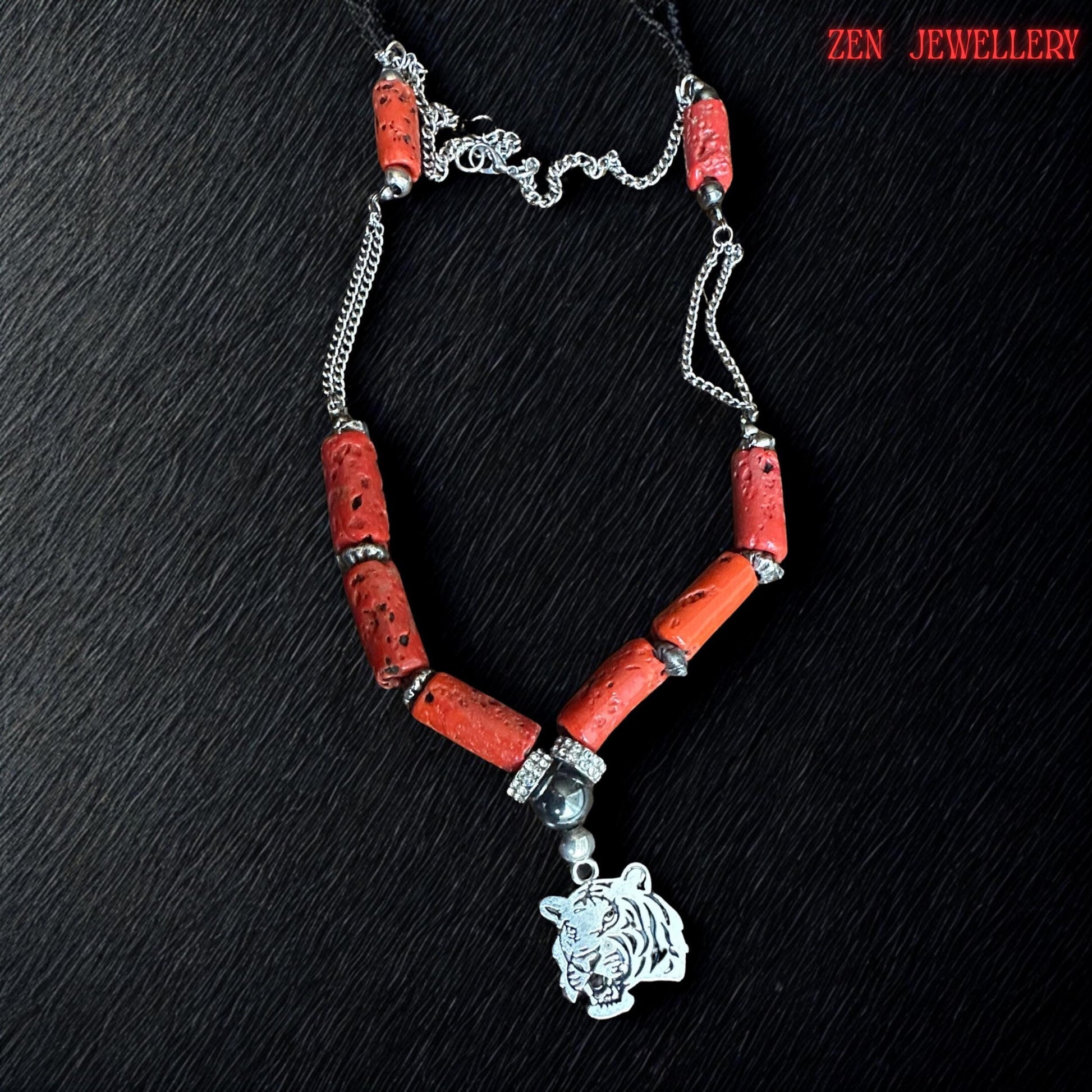 Handmade red coral jewellery necklace shown with natural cylindrical coral beads, black glossy beads, sparkling rhinestone spacers, and engraved silver tiger pendant. The mixed textures create an elegant yet edgy fashion accessory suitable for bohemian styling, statement outfits, or meaningful gifts. Necklace length approximately 22.8 inches.