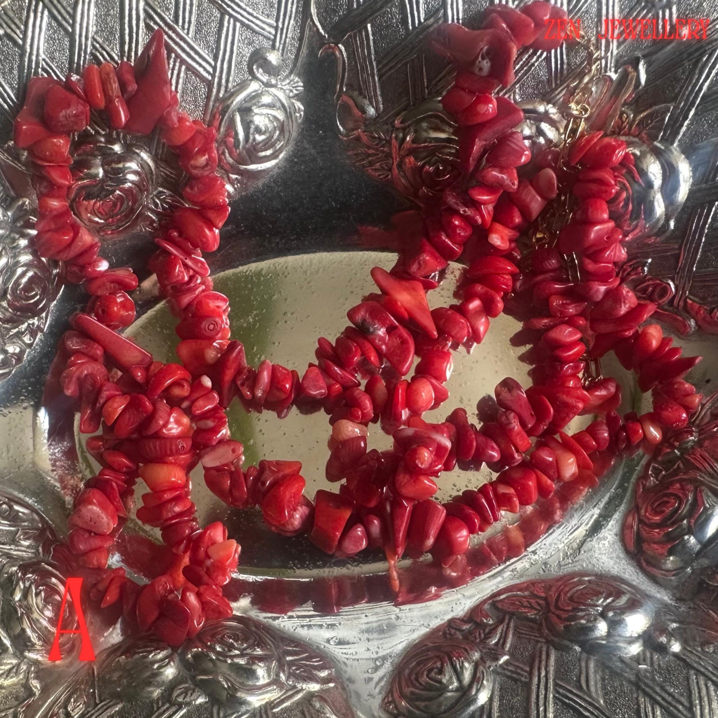 Handmade red coral statement necklace shown in close detail with rich coral-red tones and irregular gemstone chip textures arranged along the necklace strand. The matching bracelet complements the design perfectly and creates a coordinated handmade jewellery set suitable for gifts or occasion wear.