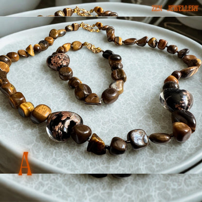Handmade tiger eye jewellery set with warm caramel and golden brown gemstone beads arranged in a matching necklace and bracelet design. The polished stones create soft reflective shine, while the gold clasps and spacer beads add elegant detail and a luxurious handcrafted finish perfect for everyday styling or gifting. A glass heart in the middle of the necklace and bracelet.