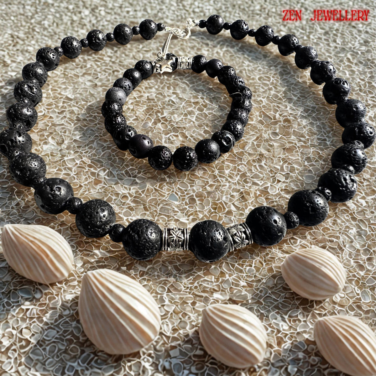 Elegant close-up of the lava stone necklace clasp and silver extension chain showing the handcrafted finishing details of the jewellery set. The black volcanic beads have a natural porous texture with subtle surface details that make each stone unique. The silver artisan spacers and small star charm create contrast against the matte black beads while adding sophistication and symbolism to the design. The jewellery on sand and shells design