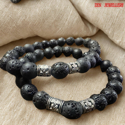 Elegant close-up of the lava stone bracelet clasp and silver extension chain showing the handcrafted finishing details of the jewellery set. The black volcanic beads have a natural porous texture with subtle surface details that make each stone unique. The silver artisan spacers create contrast against the matte black beads while adding sophistication and symbolism to the design.