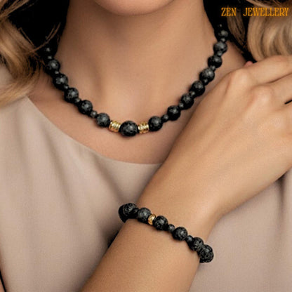 Matching lava stone bracelet shown with matte black volcanic beads and decorative gold spacer accents. The porous natural lava stones create an earthy bohemian aesthetic, while the polished golden details add elegance and sophistication. The bracelet fits comfortably on the wrist and pairs beautifully with the coordinating necklace for a timeless handcrafted jewellery set.