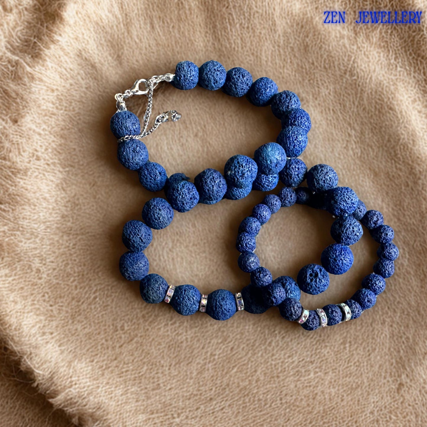 The necklace and bracelet set features dark navy blue lava stone beads with porous volcanic texture and decorative rhinestone spacers that add gentle sparkle. The handmade jewellery style feels modern, calming, and versatile, making it perfect for layered styling, casual fashion, or spiritual jewellery collections.
