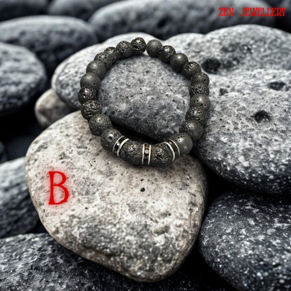 Minimalist black lava bracelet styled on a natural stone background, highlighting the porous volcanic texture and handmade craftsmanship. The bracelet combines matte black beads with sparkling black rhinestone spacers creating modern boho jewellery suitable for casual outfits or layered styling.