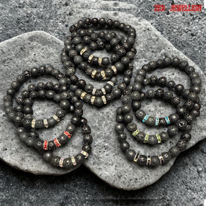 Healing energy bracelet made of lava stones with red, blue, and green rhinestones, elastic and stylish. Elegant handmade bracelets featuring black lava stones and silver rhinestone spacers for women. Natural lava stone bracelets with mixed volcanic bead sizes arranged symmetrically around bright red, black, green, turquoise crystal spacer rings. The bracelets has grounding earthy texture with subtle sparkle details and modern handmade design.