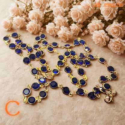 Detailed photograph of the cobalt blue crystal necklace captures the vivid sapphire-inspired tones and brilliant faceted surfaces of the gemstones. The gold-tone chain adds warmth and luxurious shine while the rich blue crystals create celestial beauty inspired by night skies and ocean reflections. The coordinated bracelet complements the necklace perfectly for a complete, elegant jewellery ensemble.