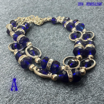 Front-facing bracelet photograph focusing on the central section where royal blue crystals and sparkling rhinestone spacers create a striking focal point. Silver-tone beads add brightness and sophistication to the overall composition. The contrast between the deep blue faceted crystals and polished metallic details creates an elegant statement accessory suitable for evening wear, celebrations, formal occasions, and stylish everyday fashion looks.