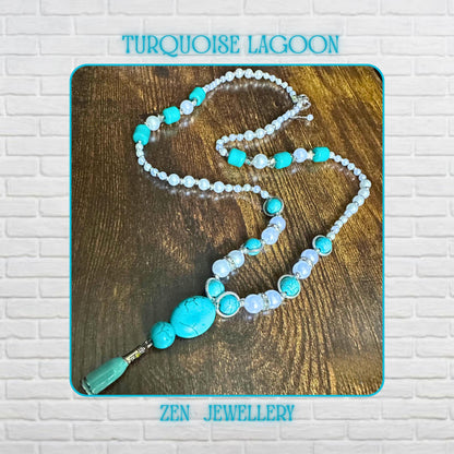 A long handmade TURQUOISE PEARL necklace displayed on a rustic wooden background featuring vibrant turquoise stones, creamy pearl beads, sparkling rhinestone spacers, and sterling silver clasps. The necklace features a large oval turquoise centrepiece with delicate tassel detailing, creating an elegant boho-chic look. The layered arrangement highlights the luxurious textures and artisan craftsmanship, perfect for vintage turquoise jewellery lover