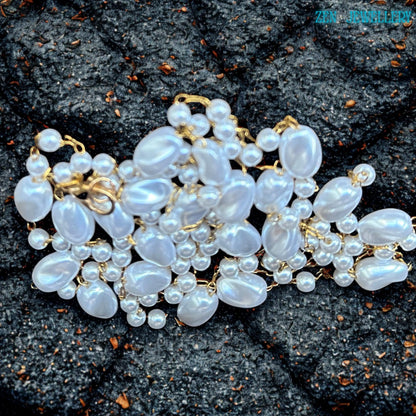 The romantic handmade necklace features flowing white pearl-style beads connected with elegant gold chain links in an airy layered design. The glossy beads create soft shine and texture while the warm gold details add refinement and elegance. The necklace works beautifully with bridal styling, summer dresses, evening outfits, or layered jewellery looks.