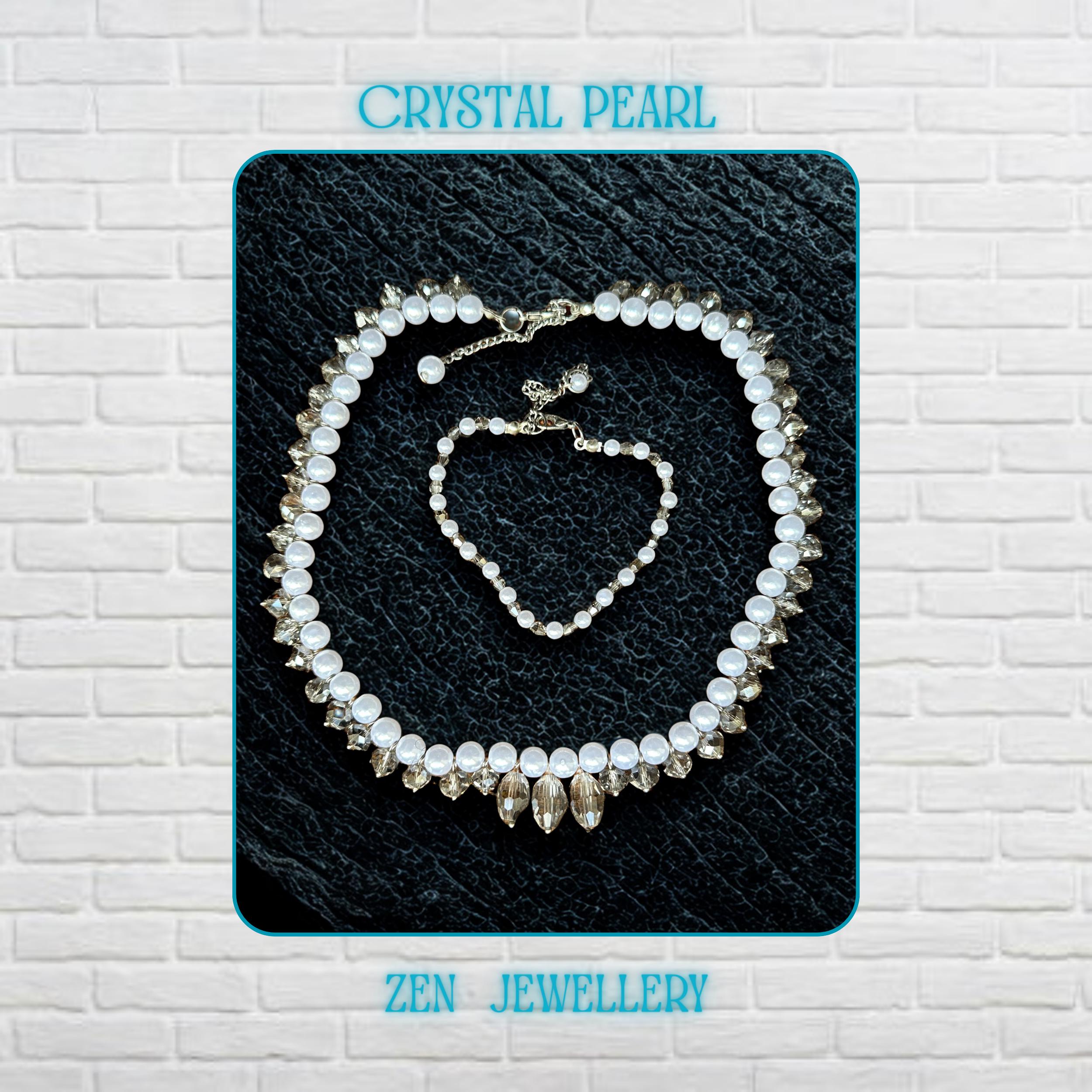 Close-up view of a handmade white pearl jewellery set with sparkling grey crystal accents and silver rhinestone spacer details arranged on a dark textured surface. The necklace features alternating glossy pearl-style beads and faceted crystal beads creating elegant texture and contrast. The matching bracelet includes delicate silver chain details and a secure clasp closure. This lightweight bridal-inspired jewellery set creates a romantic and lux