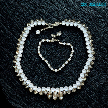 Elegant white pearl and crystal necklace set photographed flat on a textured black surface showing the detailed bead arrangement and sparkling crystal reflections. The necklace combines classic pearl beauty with modern crystal styling while the bracelet complements the design with matching white beads and silver details. The soft glossy finish gives the jewellery a luxurious and graceful appearance suitable for weddings parties and meaningful gif