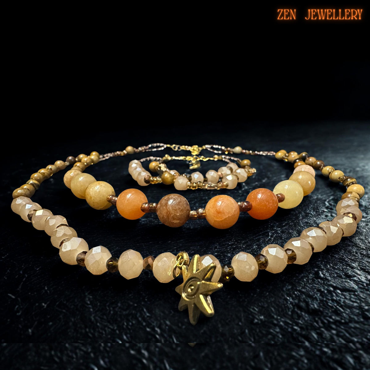 Handmade necklace and bracelet set displayed on a dark textured surface to highlight the warm gemstone colours. The gold spacer beads and clasp stand out beautifully against the earthy background.
Layered gemstone jewellery set with coordinated necklace and bracelet pieces. The beads are arranged evenly for balance, and the warm tones create a soft glowing boho look suitable for everyday wear or special occasions.
Elegant handmade jewellery piece