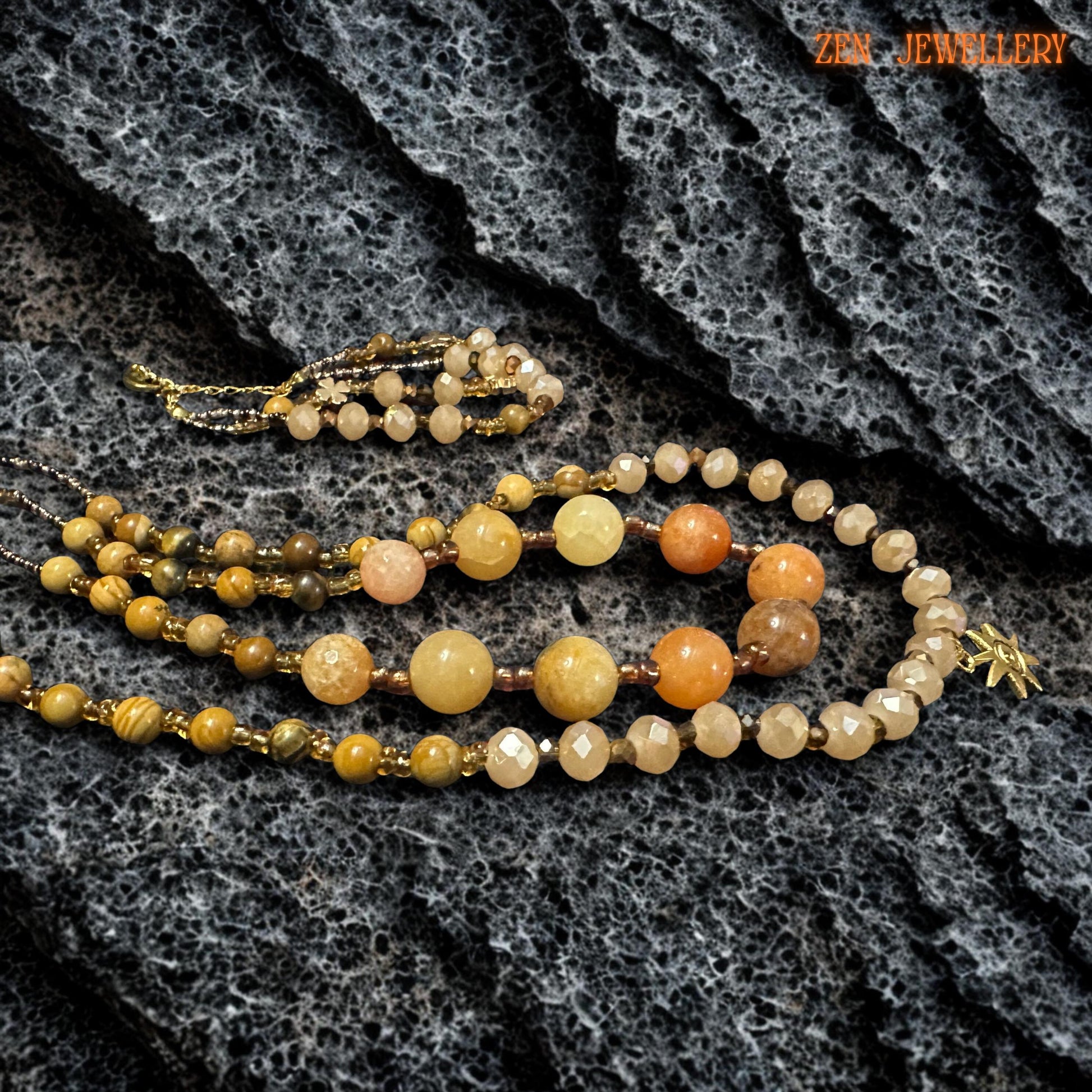 Handmade layered necklace featuring champagne crystal beads and amber-toned gemstones with gold spacer beads between each section. The coordinated bracelet complements the necklace and creates a balanced set.
Detailed view of the yellow jade gemstone beads showing smooth polished surfaces and natural colour variations. The golden accents bring brightness and make the set feel elegant and refined.