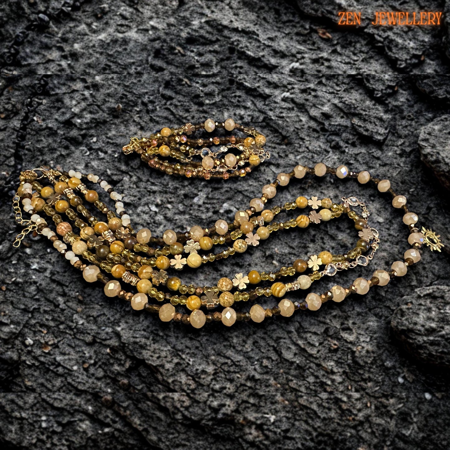 Handmade crystal necklace with natural stones and gold-plated findings displayed on a dark textured surface.