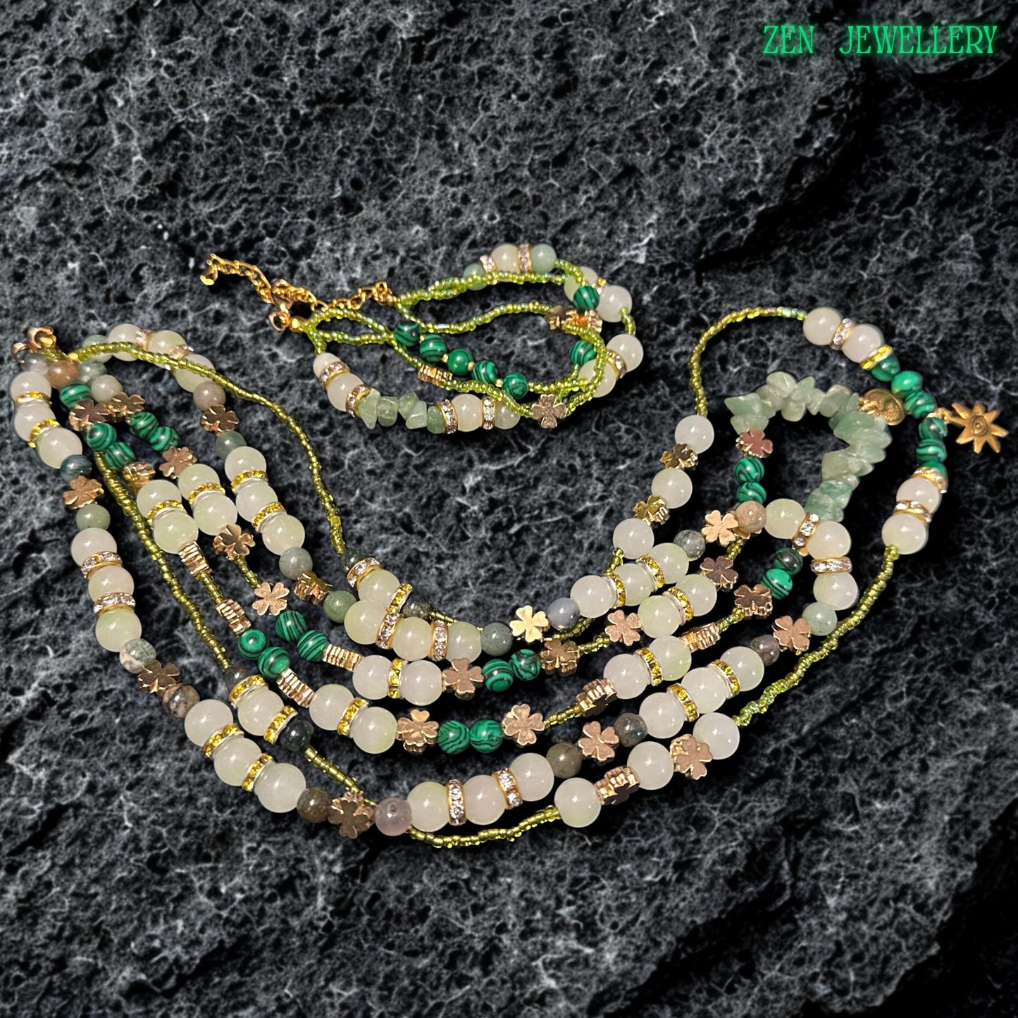 • Elegant boho jewellery set featuring layered green gemstone necklaces and matching bracelet with polished creamy beads, green striped malachite style accents, rhinestone spacer rings, and delicate gold floral charms. The combination of glossy textures, earthy colours, and celestial pendants creates a feminine artisan jewellery design perfect for festival styling and spiritual fashion lovers.