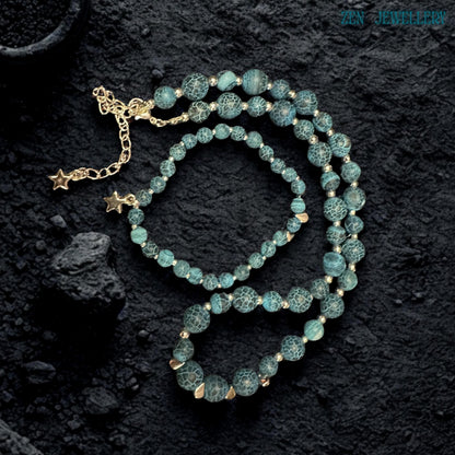 Handmade celestial jewellery set photographed in soft lighting to emphasize the natural crackled patterns within the Blue Crackle Agate gemstone beads featuring deep ocean blue, turquoise, and black tones combined with polished silver accents and star charms creating a mystical bohemian aesthetic inspired by nature, the night sky, and artisan gemstone jewellery craftsmanship.