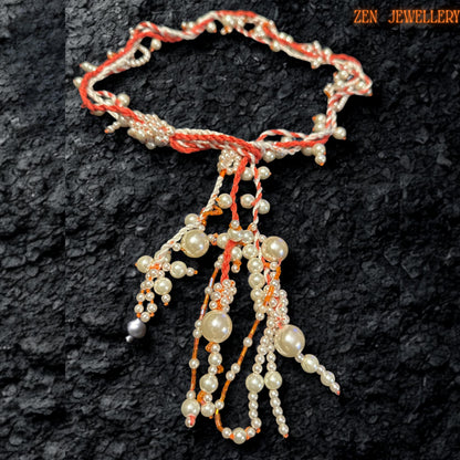 Elegant WHITE PEARL crochet necklace photographed from above to showcase the flowing arrangement of ivory pearl beads suspended from twisted coral and cream textile strands. The layered tassel design creates sculptural movement while tiny seed beads add delicate sparkle and texture throughout the necklace. The handcrafted asymmetrical structure feels artistic and organic while maintaining a luxurious, romantic appearance.