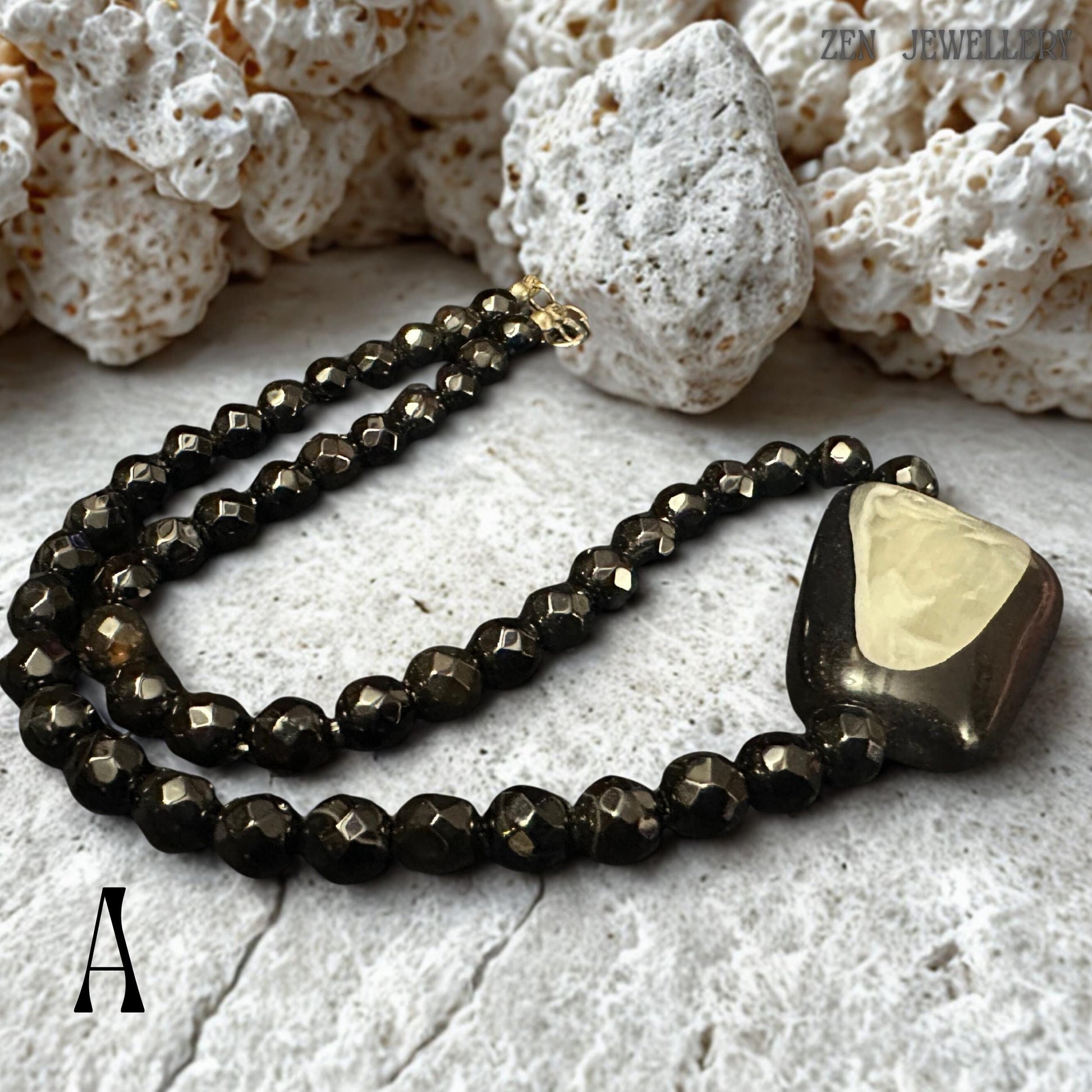 Luxury black crystal necklace and bracelet set with faceted round black beads and a dramatic asymmetrical geometric pendant featuring a pearl-like shell centrepiece. The reflective crystal beads create a subtle sparkle while the polished pendant surface adds sculptural dimension to the design. The necklace has a chic modern aesthetic suitable for black dresses, minimalist fashion, gothic elegance, and eveningwear styling.