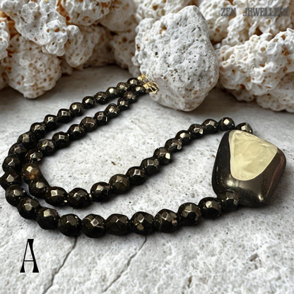 Luxury black crystal necklace and bracelet set with faceted round black beads and a dramatic asymmetrical geometric pendant featuring a pearl-like shell centrepiece. The reflective crystal beads create a subtle sparkle while the polished pendant surface adds sculptural dimension to the design. The necklace has a chic modern aesthetic suitable for black dresses, minimalist fashion, gothic elegance, and eveningwear styling.