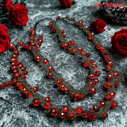 Romantic handmade RED CRYSTAL necklace featuring deep crimson faceted beads attached onto flowing black crochet cords with careful craftsmanship. The irregular crystal arrangement creates sculptural texture and natural movement while reflecting light beautifully from different angles. The soft braided strands contrast elegantly with the intense ruby sparkle and create a luxurious couture-inspired style. The necklace feels expressive, feminine, ar