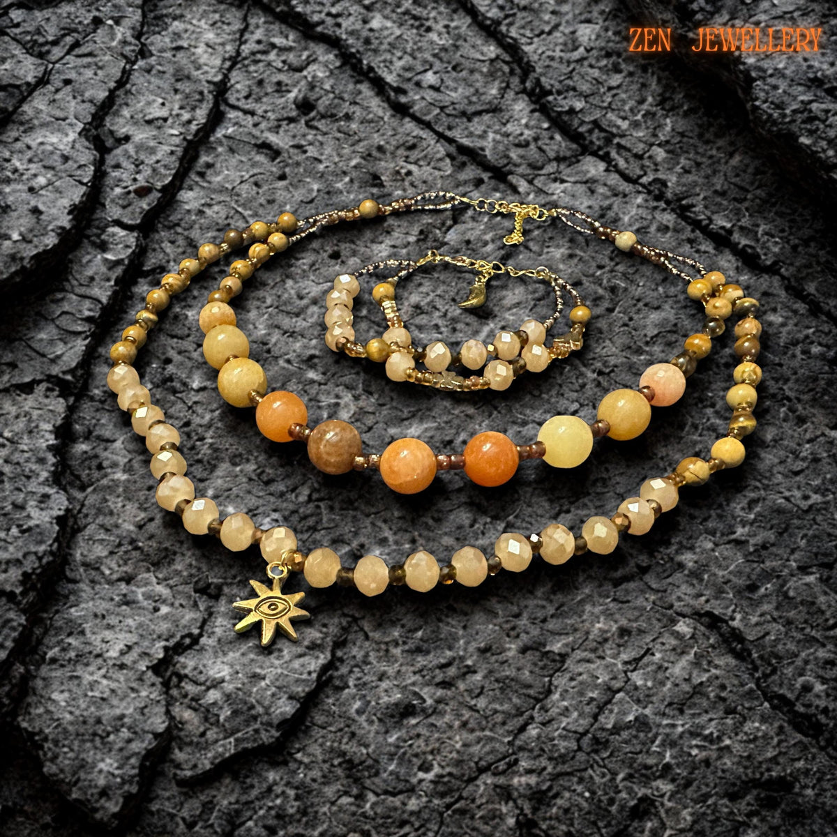 Handmade jade gemstone jewellery with honey, caramel, beige, and golden tones displayed on a dark stone surface. The reflective crystal beads catch the light softly, giving the necklace a warm glowing finish and a refined boho style.