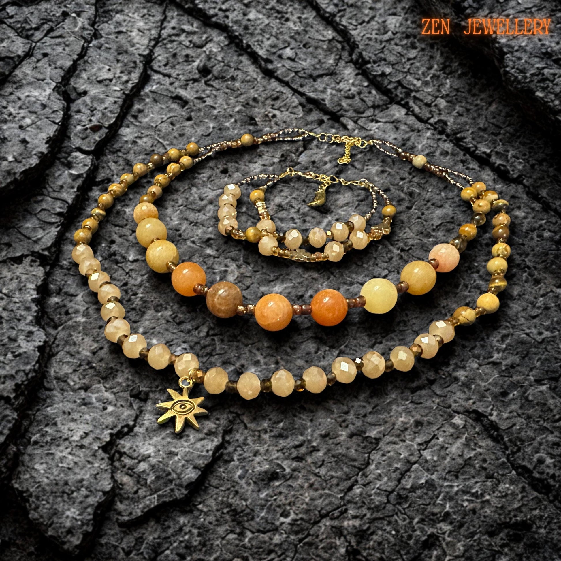 Handmade jade gemstone jewellery with honey, caramel, beige, and golden tones displayed on a dark stone surface. The reflective crystal beads catch the light softly, giving the necklace a warm glowing finish and a refined boho style.