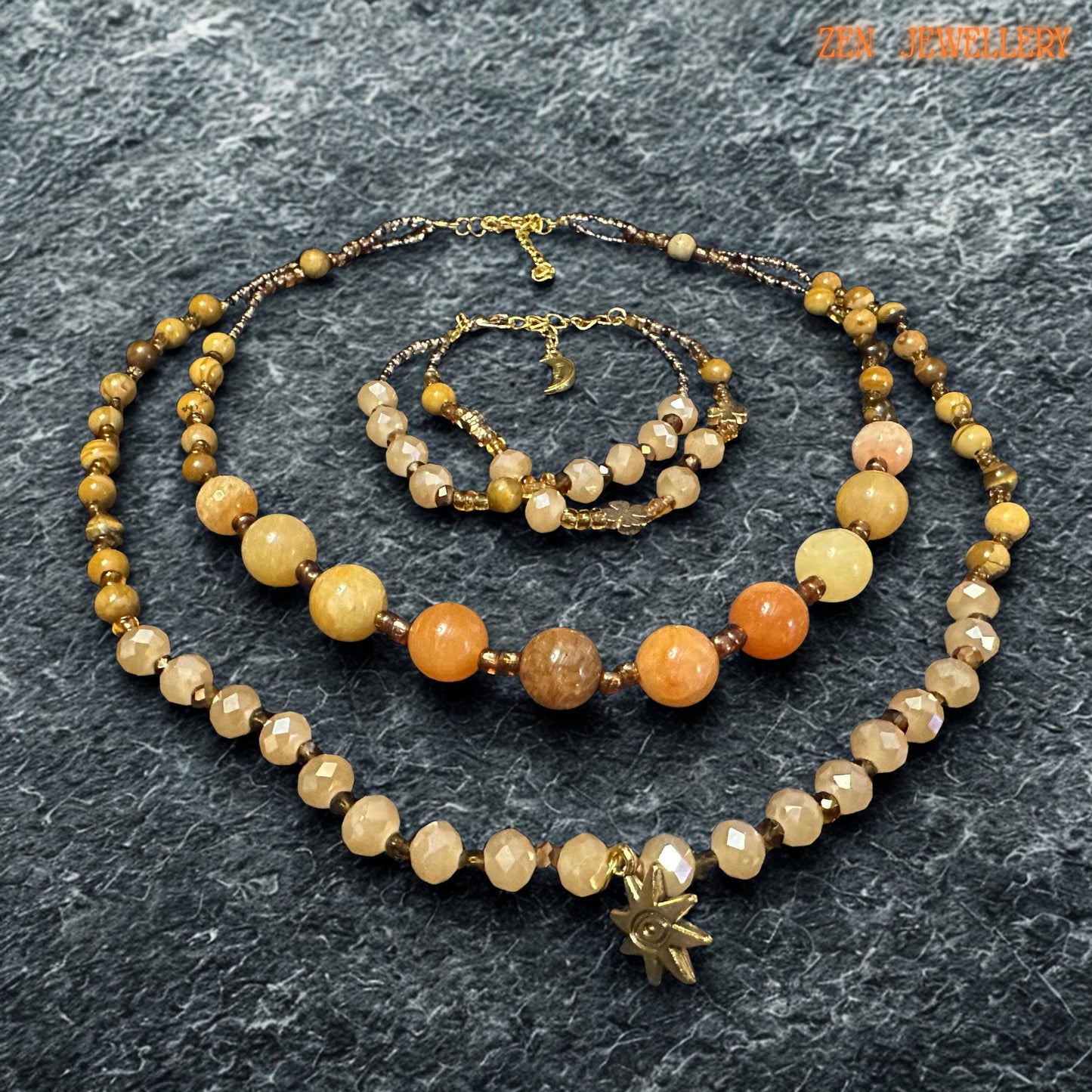 Elegant handmade jewellery piece featuring yellow jade, honey jade, and champagne crystal beads. The natural-looking gemstone tones create a calming earthy style, while the gold accents add luxury and warmth.
The necklace includes two layered strands with different bead sizes for added interest and movement. The bracelet repeats the same colour palette and handcrafted feel for a complete jewellery set.
