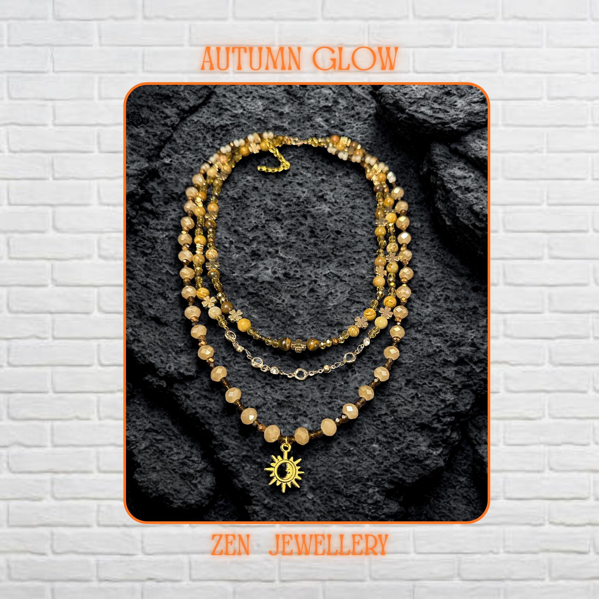 Close-up of natural gemstone beads in beige, brown, and gold shades forming a triple-strand boho necklace.