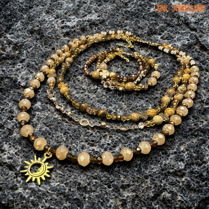 Gold sun pendant hanging from a beaded boho necklace made of warm autumn stone colours.