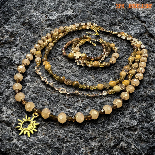Gold sun pendant hanging from a beaded boho necklace made of warm autumn stone colours.