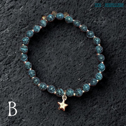 Artistic flat-lay photograph showing the complete Blue Crackle Agate jewellery set arranged naturally on a black textured stone surface emphasizing the rich turquoise colours, organic crackled bead textures, silver metallic details, and celestial star charms while creating dramatic contrast that highlights the gemstone depth, layered necklace design, and elegant handcrafted composition from a slightly elevated viewing angle.