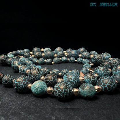 Layered gemstone jewellery set featuring Blue Crackle Agate beads arranged naturally on textured black stone creating dramatic visual contrast that enhances the turquoise crackled bead surfaces, polished silver accents, and celestial star charms while showcasing the luxurious handcrafted quality, artistic gemstone patterns, and sophisticated bohemian fashion aesthetic.