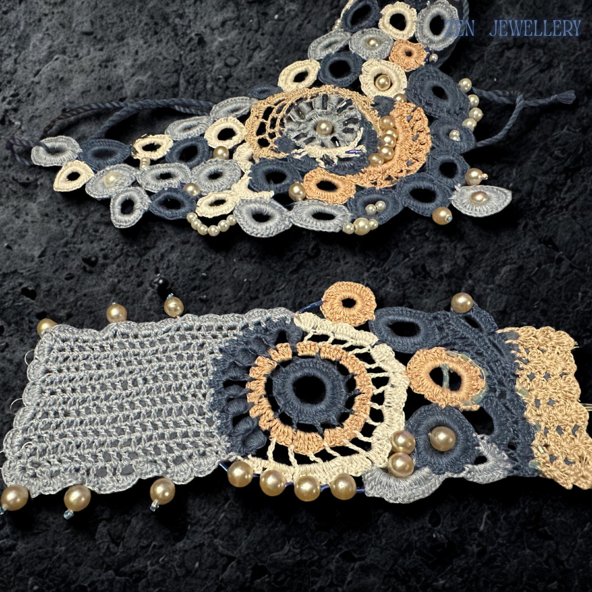 Blue and white crochet necklace photographed from above to highlight the intricate textile construction pearl placement and dimensional concentric design featuring soft dusty blue ivory champagne and navy colour combinations creating a romantic feminine couture jewellery appearance with artisanal handmade character.