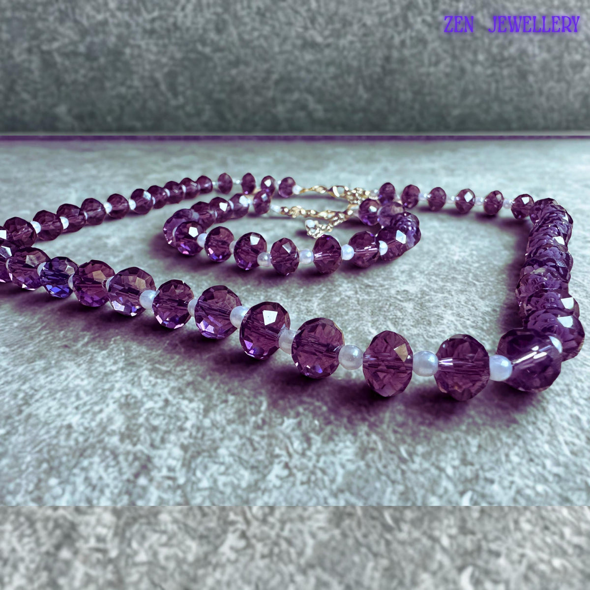 Coordinated crystal necklace and bracelet set featuring deep lavender purple faceted beads separated by glossy white pearl style spacer beads with adjustable silver extension chains and elegant handcrafted styling.