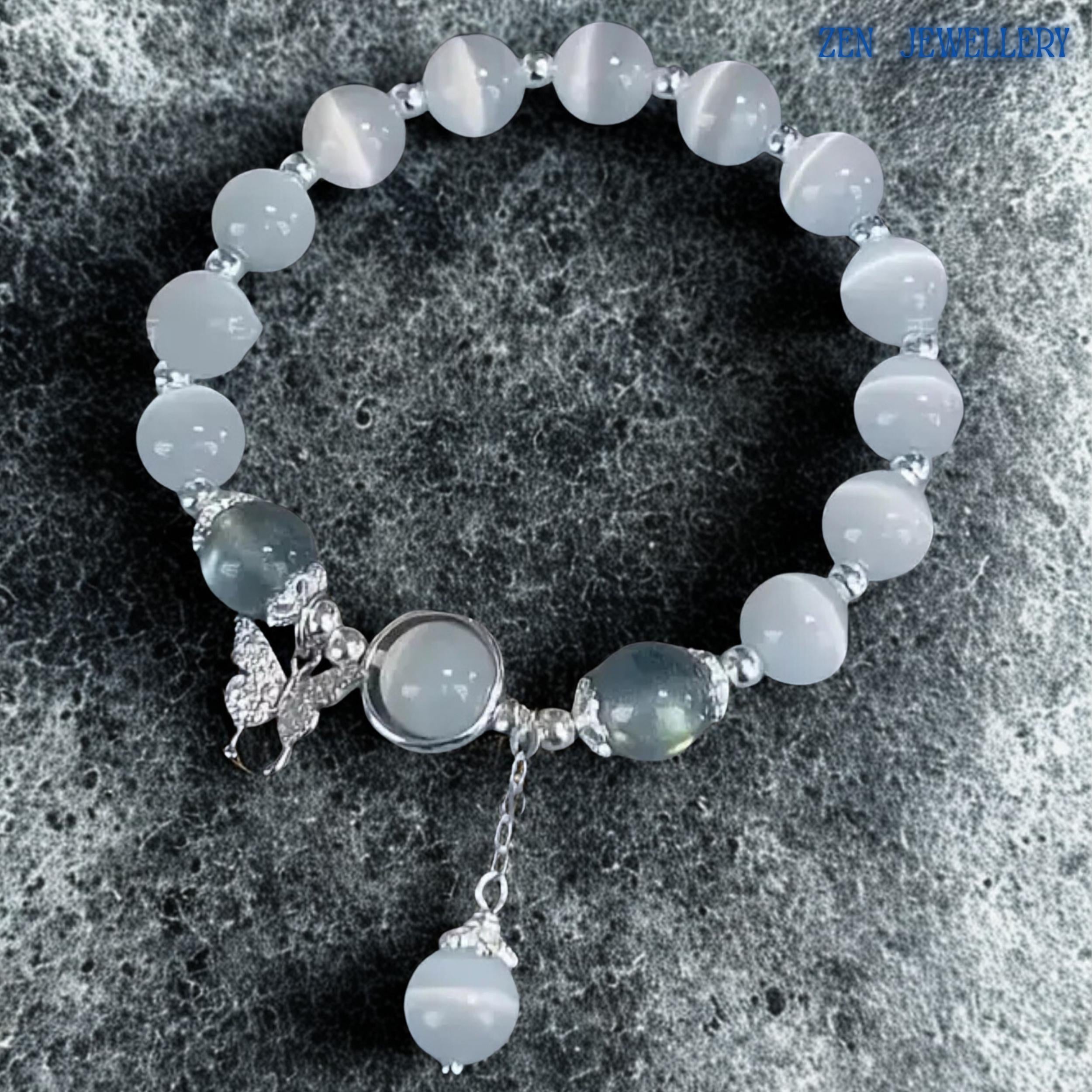 Bracelet shown against textured stone surface providing scale and context, allowing buyers to appreciate the proportions of the gemstone beads, decorative silver accents and dangling charm elements while highlighting the elegant arrangement and handcrafted quality that contribute to its timeless and versatile jewellery appeal.