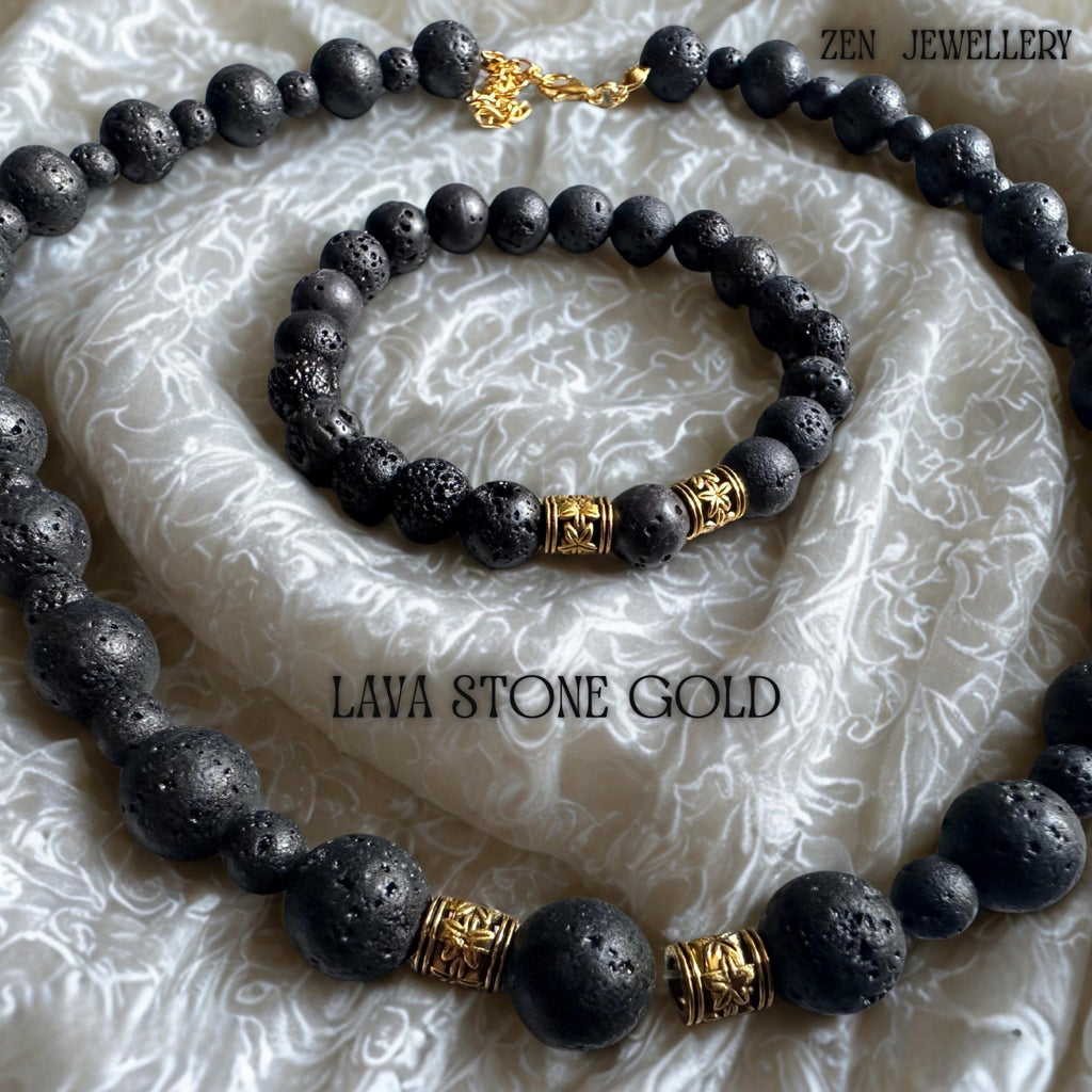 Elegant close-up of the necklace clasp and golden extension chain, highlighting the refined handmade details of the volcanic bead jewellery set. The natural lava stones feature a porous matte surface with organic texture variations that make each piece unique. The combination of black volcanic beads and warm gold accents creates a balanced, minimalist bohemian style.