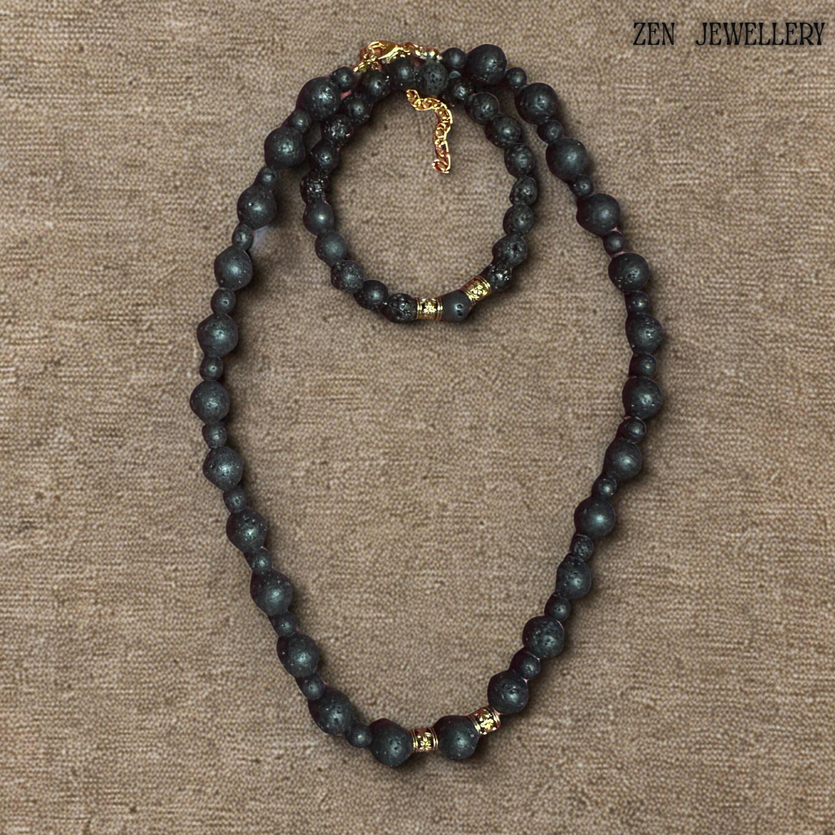 Handmade black lava stone jewellery set with textured volcanic beads, golden artisan spacers, and a warm earthy minimalist aesthetic. The necklace and bracelet feature carefully balanced bead sizes and elegant gold-tone closures that create a timeless handcrafted appearance inspired by natural volcanic materials and modern bohemian fashion.