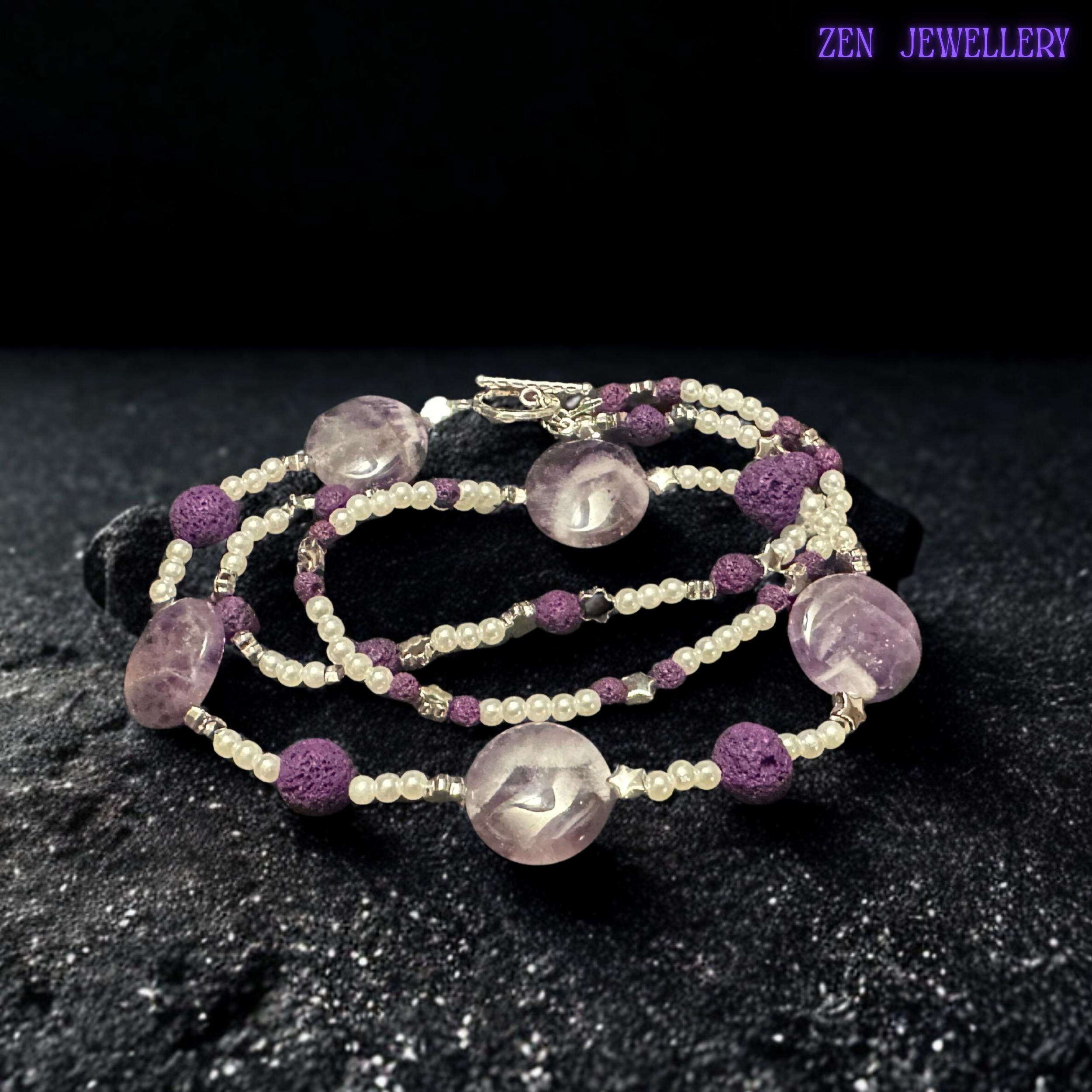 This amethyst-inspired necklace combines polished lavender beads, textured lava stones, silver accents, and delicate pearl-style spacers in a balanced handmade design. The artistic arrangement creates a lightweight statement necklace full of texture and feminine charm.