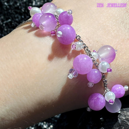 Handmade pastel crystal bracelet displayed on model wrist. The bracelet features silver chain sections decorated with clustered gemstone beads in soft pink, pearl white, and lavender tones. The asymmetrical floral-inspired arrangement creates graceful movement and layered artistic texture. Tiny silver spacer beads and reflective details add sparkle without overpowering the delicate feminine design.