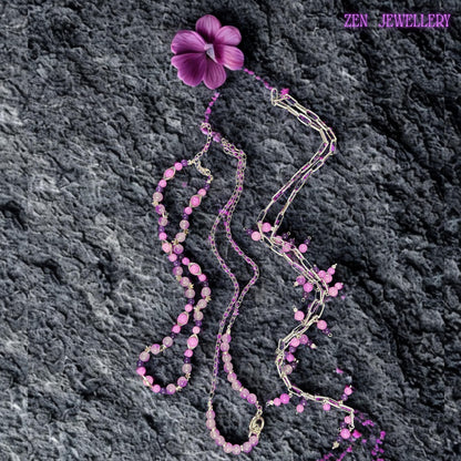 • Handmade bohemian necklace featuring chunky silver chains layered with pastel gemstone bead strands in pink, purple, lilac, and lavender tones. Small dangling bead charms attached throughout the chain sections create playful movement and elegant texture. Polished gemstone beads and crystal accents reflect soft light while the layered asymmetrical design creates depth and artistic flow across the neckline. The necklace feels romantic, feminine,