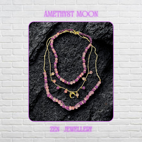 • Close-up view of the layered necklace showing polished translucent pink gemstone beads with a soft frosted glow contrasted against textured volcanic purple lava stone beads. Gold spacer rings with rhinestone sparkle separate the beads beautifully while the delicate gold chain drapes naturally across the dark decorative surface. The crescent moon charm becomes the focal point and adds mystical celestial elegance to the handmade artistic jeweller