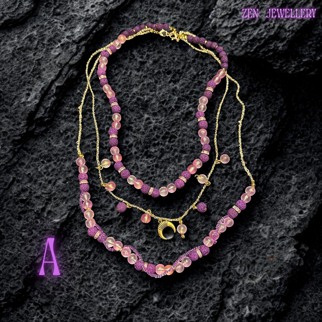 Lava stone necklace with pink glass beads and purple textured stones on gold chain
Close-up of purple lava stone beads with porous texture and matte finish
Pink translucent glass beads reflecting light softly along necklace