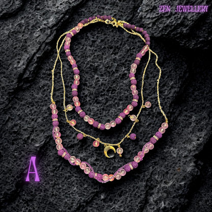 Lava stone necklace with pink glass beads and purple textured stones on gold chain
Close-up of purple lava stone beads with porous texture and matte finish
Pink translucent glass beads reflecting light softly along necklace