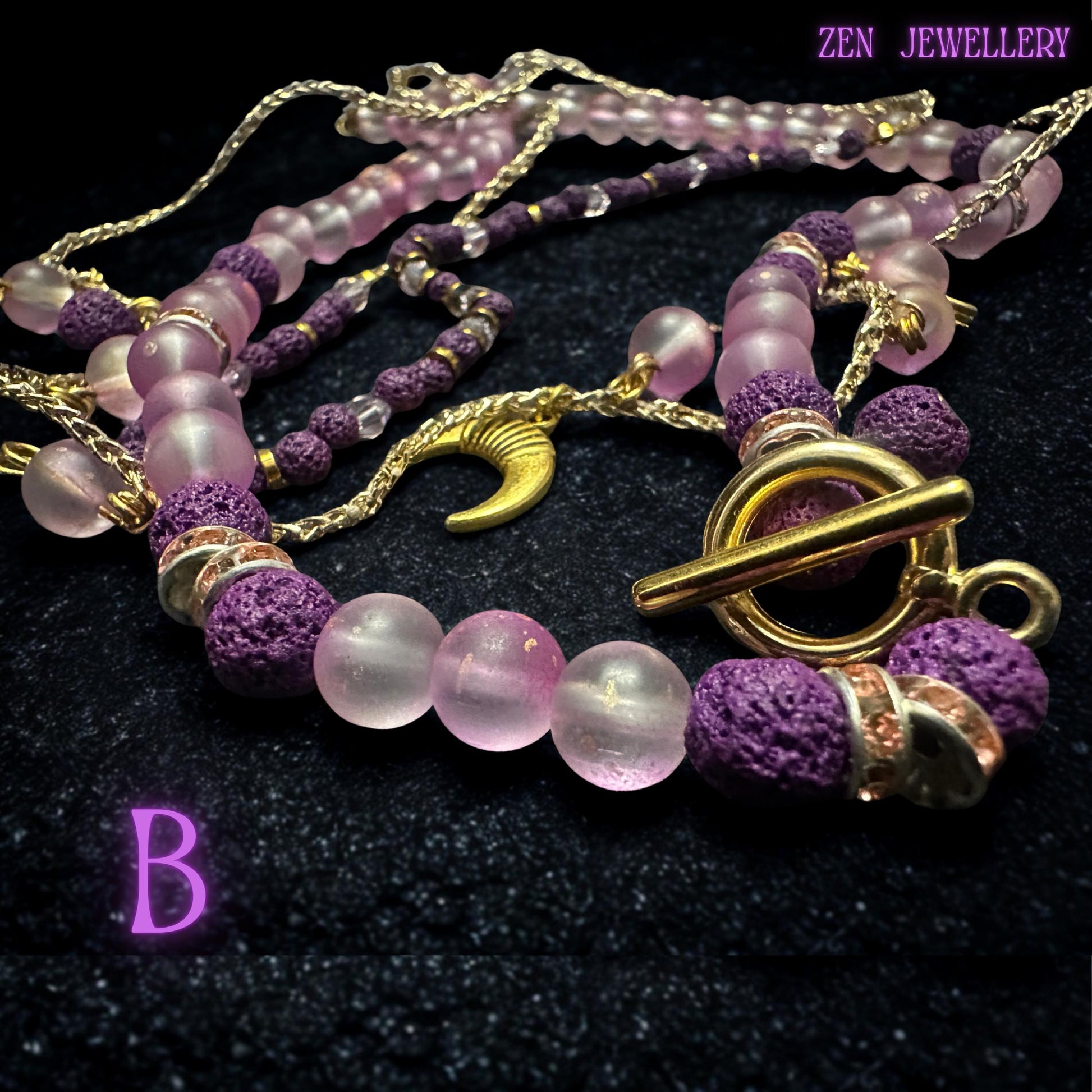 • Elegant flat-lay photograph showing the layered necklace carefully arranged to reveal the graceful drape and flowing movement of the fine gold chain strands. Small dangling gemstone charms attached to the chain create playful detail while the crescent moon pendant anchors the celestial design beautifully. The soft pink and purple palette gives the jewellery set a dreamy romantic appearance.