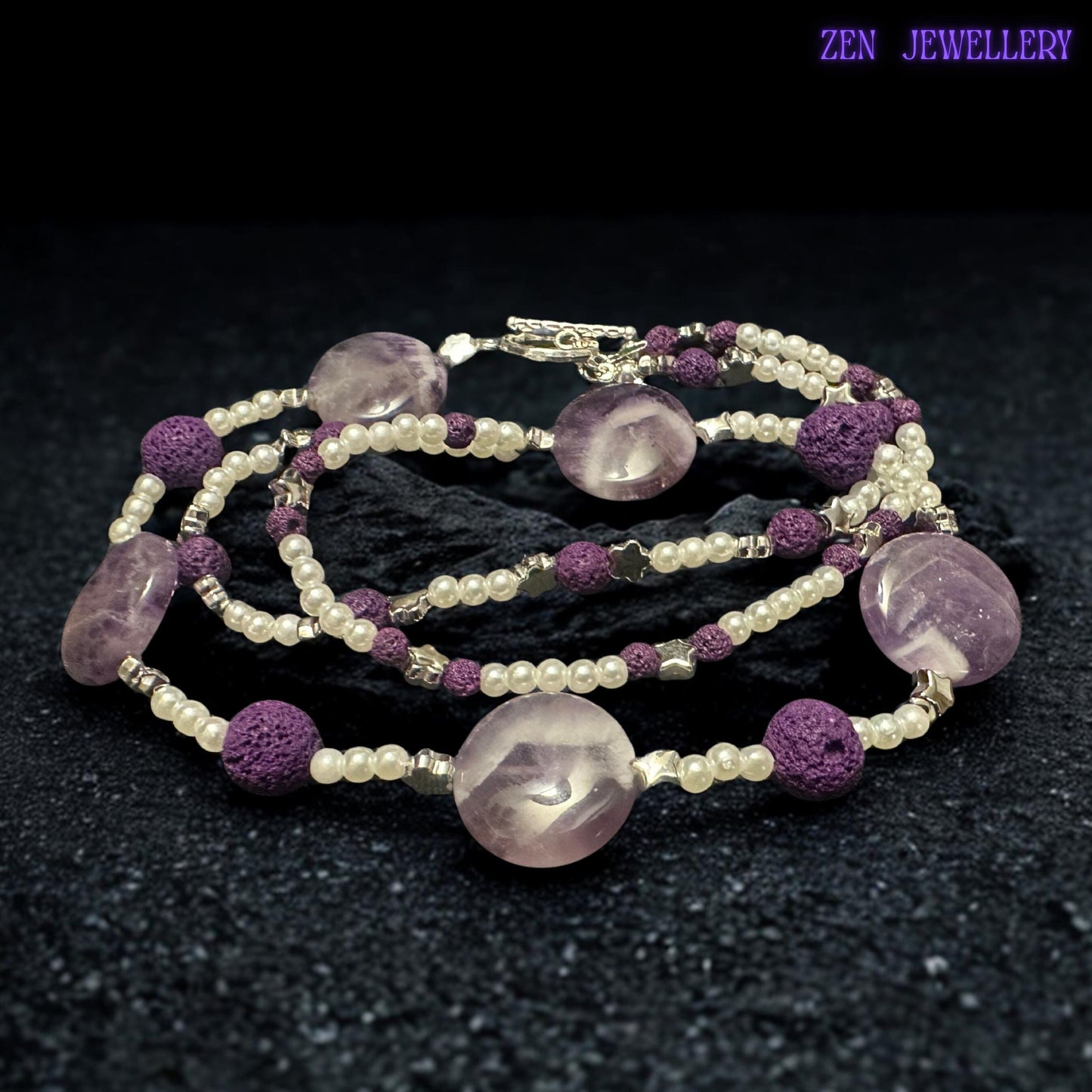 The silver toggle clasp and dangling bead details give this handmade purple necklace a unique artisan finish. The textured lava stone beads add depth and contrast while the glossy crystal-style beads create soft sparkle and luxurious movement.