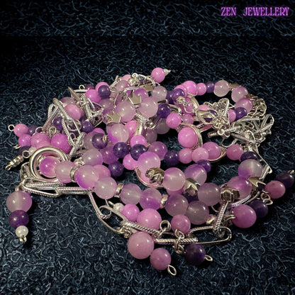 • Artistic handmade necklace featuring three layered strands combining chunky silver chain details with pastel gemstone beads in pink, lilac, lavender, and purple shades. Small dangling bead charms attached to the chain links create playful movement and layered texture throughout the design. The polished glossy beads reflect soft light beautifully, while faceted crystal accents add elegant sparkle.