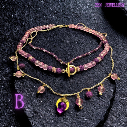 • Artistic jewellery composition featuring the layered AVENTURINE necklace and bracelet arranged together to highlight the coordinated beadwork and celestial details. The rich purple volcanic beads provide bold earthy texture while the blush pink gemstone beads soften the overall appearance. The combination of gold chain strands, rhinestone spacers, and moon pendant creates a luxurious feminine bohemian jewellery set.
