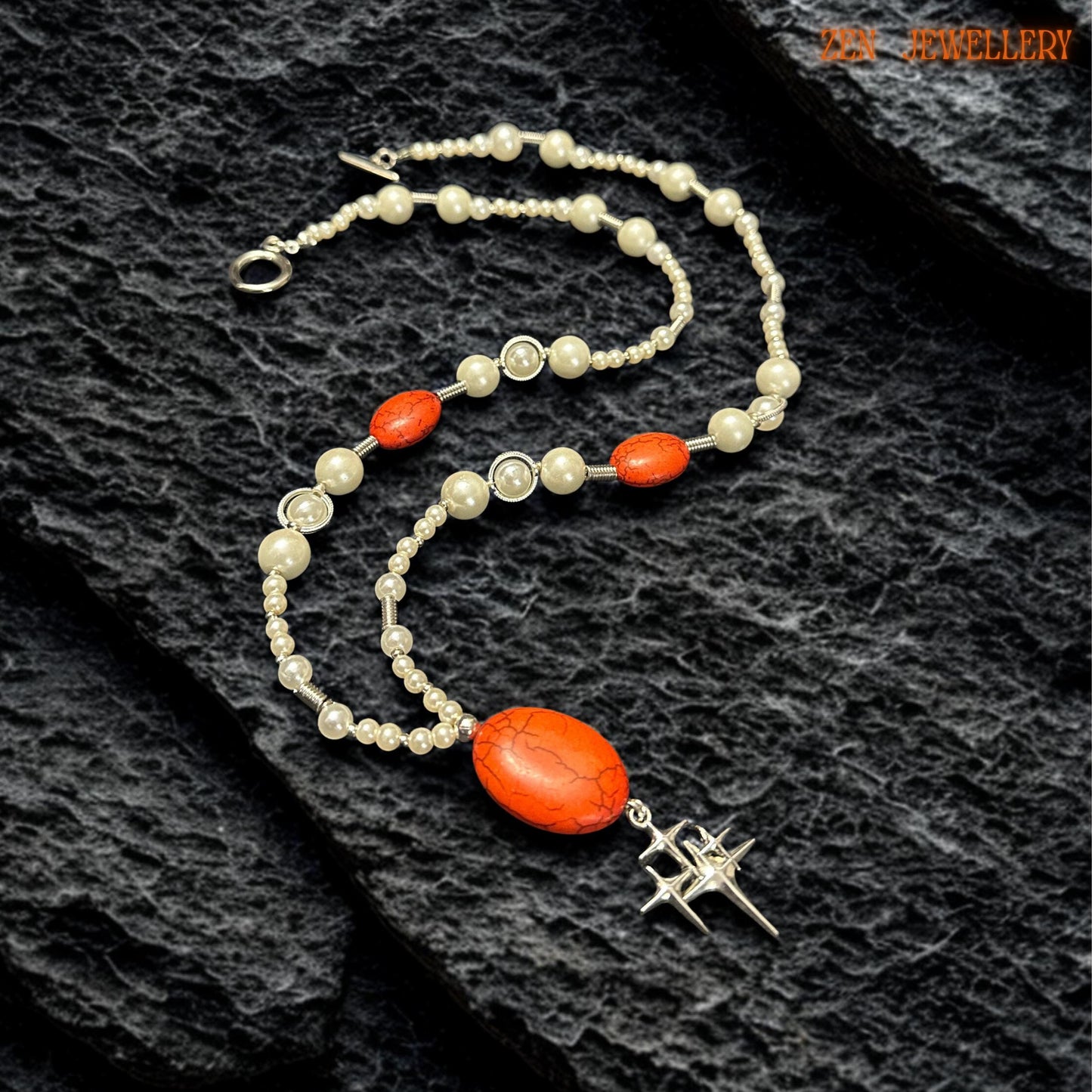 Full necklace view worn on a model displaying creamy white pearl-style beads mixed with coral-red gemstone accents and silver metallic spacers. The centre pendant creates graceful movement while the silver celestial star charm adds symbolic meaning connected to hope, positivity, and guidance.
